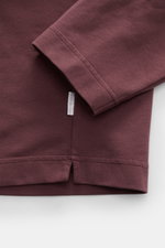 Detailaufnahme des bordeauxfarbenen 04651/ A trip in a bag Longsleeve 'IF Tee' mit Fokus auf Ärmel und Saum, Jersey aus elastischer Baumwolle, sehr weicher Griff, Regular Fit, Rundhalsausschnitt, kurze Saumschlitze, fotografiert von oben.