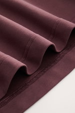 Nahaufnahme des bordeauxfarbenen 04651/ A trip in a bag Longsleeve 'IF Tee' mit elastischem Baumwoll-Jersey, weichem Griff, Regular Fit, Rundhalsausschnitt und kurzen Saumschlitzen, aus schräger Perspektive fotografiert.