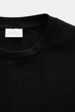 Nahaufnahme des Rundhalsausschnitts und Etiketts des schwarzen 04651/ A trip in a bag Longsleeve 'IF Tee' aus elastischer Baumwolle mit weichem Griff.