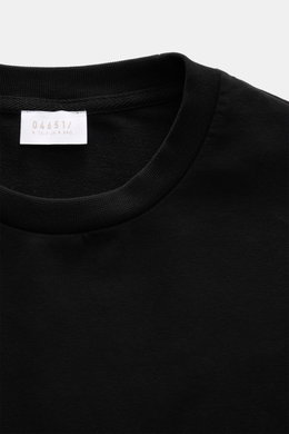 Nahaufnahme des Rundhalsausschnitts und Etiketts des schwarzen 04651/ A trip in a bag Longsleeve 'IF Tee' aus elastischer Baumwolle mit weichem Griff.
