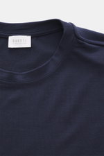 Close-up front view of the navy 04651/ A trip in a bag Longsleeve 'WJ Tee' showing round neckline and label; versatile basic with wool microfiber mix, soft feel, regular fit, and short hem slits, ideal for layering on cooler days.