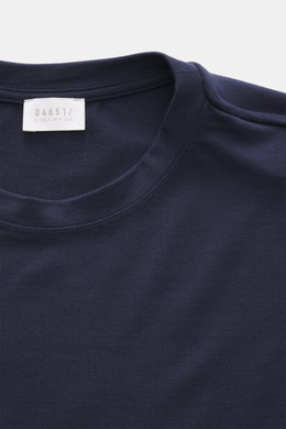 Close-up front view of the navy 04651/ A trip in a bag Longsleeve 'WJ Tee' showing round neckline and label; versatile basic with wool microfiber mix, soft feel, regular fit, and short hem slits, ideal for layering on cooler days.