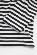 Nahaufnahme des 04651/ A trip in a bag Feinstrick-Longsleeve dark navy/offwhite gestreift, fotografiert aus seitlicher Perspektive, zeigt das weiche Feinstrickmaterial aus reiner Baumwolle mit Rundhalsausschnitt, kleinem Weblabel, Regular Fit und schwerer