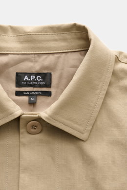 Ausschnitt des A.P.C. Overshirts 'Rodney' in Beige mit Umlegekragen und Knopfleiste aus reiner Baumwolle, Produktetikett sichtbar.