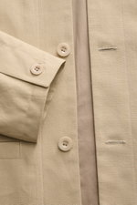 Nahaufnahme des beigen A.P.C. Overshirts 'Rodney' aus Baumwolle mit Knöpfen und Leistentasche, robust und stilvoll.
