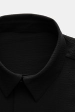 Close-up front view of the collar and upper chest of the 04651/ A trip in a bag Seersucker-Overshirt schwarz, made from wool and high-quality microfiber with a slim fit, Kent collar, garment dyed, unlined fabric showing the seersucker texture.