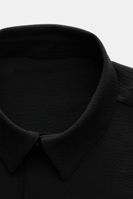 Close-up front view of the collar and upper chest of the 04651/ A trip in a bag Seersucker-Overshirt schwarz, made from wool and high-quality microfiber with a slim fit, Kent collar, garment dyed, unlined fabric showing the seersucker texture.