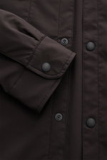 Dunkelbraunes 04651/ A trip in a bag Overshirt 'Travel' im Nahaufnahme von Ärmel und Druckknopfleiste, wind- und wasserabweisend.