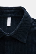 Nahaufnahme des Kent-Kragens des 04651/ A trip in a bag Cord-Overshirt navy, gefertigt aus weichem Breitcord aus Baumwolle mit Stretch-Anteil, garment dyed, oversized Schnitt, Druckknopfleiste, aufgesetzten Brusttaschen in Kontraststoff, Ärmelabschlüssen 
