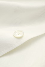 Close-up view of the Stile Latino Overshirt 'Gbu Teseo' cream button on pure cotton fabric, showing soft texture and fine detail.

<p>Luxurious layers: This sophisticated overshirt by STILE LATINO combines exquisite quality with timeless elegance – a styl