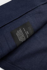 Close-up of the Zegna Overshirt navy fabric texture and label, photographed from a top-down angle showing fine twill weave.

<p>This overshirt by ZEGNA, made from linen and wool, embodies Italian casual style with its pleasantly soft feel and denim look –