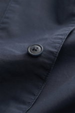 Nahaufnahme eines Knopfs mit C.P. Company Schriftzug auf dem navy C.P. Company Overshirt navy aus reiner Baumwolle, Slim Fit, leichte Qualität.