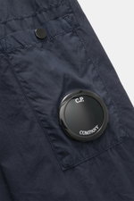 Nahaufnahme des C.P. Company Overshirt navy in Slim Fit, reine Baumwolle, mit Manschette, Fronttasche und Logodetail am Ärmel.