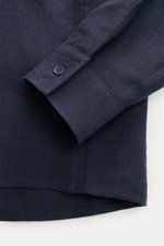 Nahaufnahme des Percival Leinen-Overshirts navy von unten rechts, zeigt Ärmel mit Knopf und leicht gerundeten Saum aus reinem Leinen.