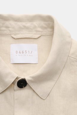 Nahaufnahme des beigen 04651/ A trip in a bag Overshirt 'Linen Jacket' aus reinem Leinen, Slim Fit, mit Umlegekragen und Knopf, von oben fotografiert.