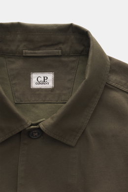 Nahaufnahme von Kragen und oberem Bereich des C.P. Company Overshirt khaki, Slim Fit, reine Baumwolle, leicht griffig, glatte Knopfleiste, Umlegekragen.