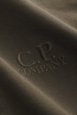 Nahaufnahme des C.P. Company Overshirt khaki aus reiner Baumwolle mit leicht griffiger Haptik, Slim Fit, glatter Knopfleiste, Umlegekragen, Fronttaschen mit Patte und Ärmelabschlüssen mit Manschette, Detailfoto der Stoffstruktur.