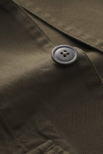 Nahaufnahme aus schräger Perspektive des C.P. Company Overshirt khaki mit glatter Knopfleiste, Umlegekragen, Fronttaschen und Manschetten, reine Baumwolle, leicht griffige Haptik, Slim Fit.