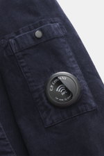 Nahaufnahme des C.P. Company Cord-Overshirt navy aus elastischem Baumwollcord mit Druckknopftasche und labeltypischem Linsen-Detail, Slim Fit.