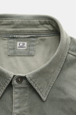 Close-up front view of C.P. Company Cord Overshirt Grey Green collar and label, showcasing soft elastic cotton corduroy texture.

Description: Casualwear with character: The Cord Overshirt from C.P. COMPANY impresses with soft cotton quality, distinctive 