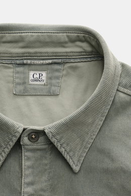 Close-up front view of C.P. Company Cord Overshirt Grey Green collar and label, showcasing soft elastic cotton corduroy texture.

Description: Casualwear with character: The Cord Overshirt from C.P. COMPANY impresses with soft cotton quality, distinctive 