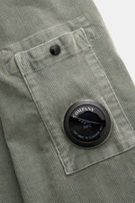 Close-up front view of the C.P. Company Cord Overshirt Grey Green showing corduroy texture, chest pocket with button, and lens detail.

Description: 
<p>Casualwear with character: The Cord Overshirt from C.P. COMPANY impresses with soft cotton quality, di