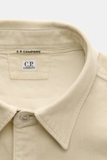 Nahaufnahme des umgelegten Kragens und Etiketts vom C.P. Company Cord-Overshirt sand, weicher Cord mit markanter Struktur, Slim Fit.