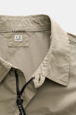 C.P. Company Overshirt graugrün aus samtiger Baumwollgabardine, Slim Fit, mit Umlegekragen, Reißverschluss und labeltypischem Linsen-Detail, Nahaufnahme von innen.