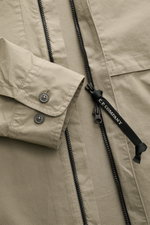 Nahaufnahme aus schräger Perspektive des C.P. Company Overshirt graugrün aus samtiger Baumwollgabardine mit Slim Fit, zwei-Wege-Reißverschluss, Umlegekragen, regulierbaren Ärmelabschlüssen, Brusttaschen mit Patte, Druckknopftasche am Oberarm und labeltypi