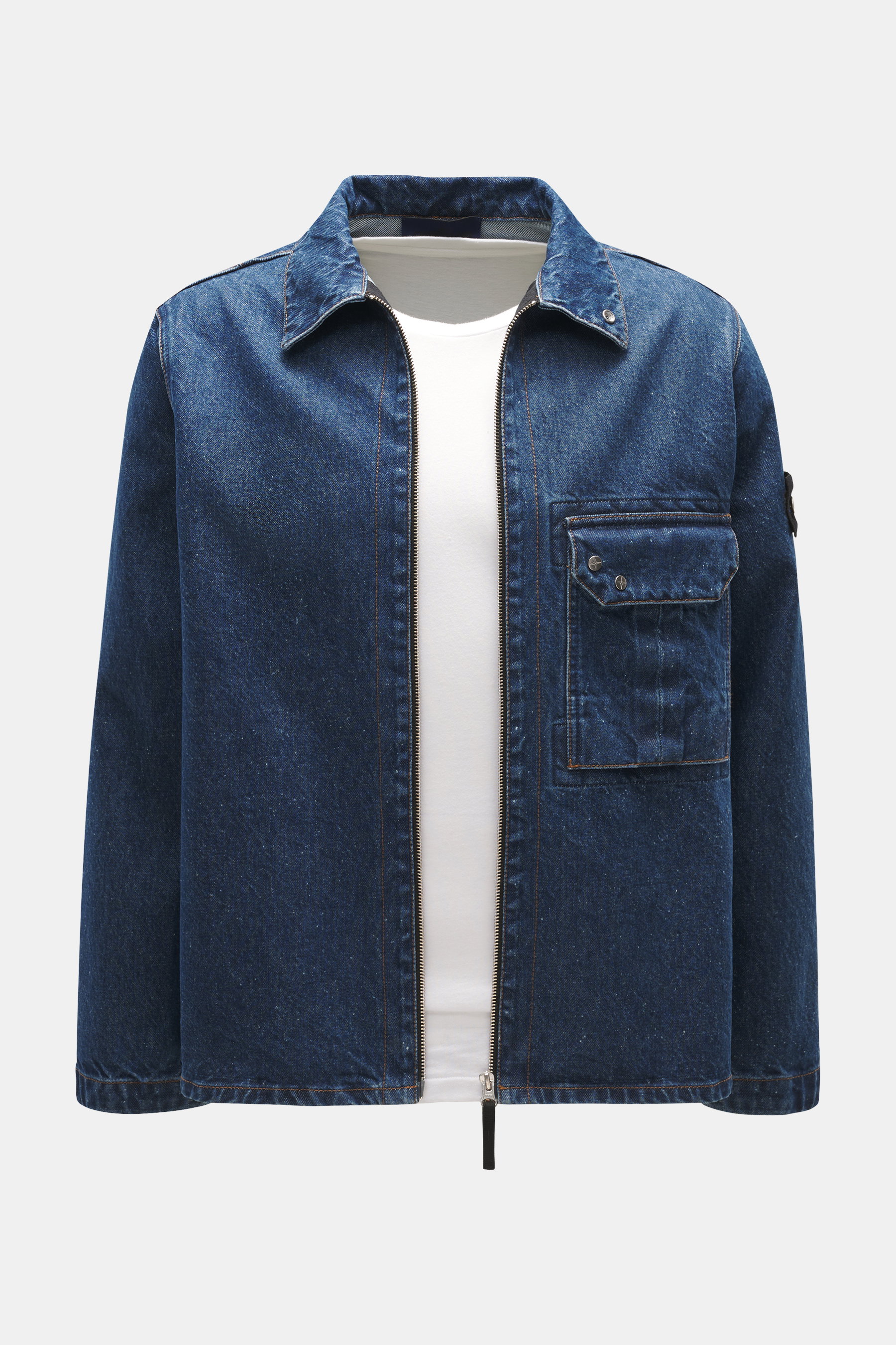 Stone Island Blue denim jacket front view, slim fit with turn-down collar, two-way zipper, patch chest pocket, compass badge on upper arm, denim made of pure cotton with typical material texture.