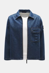 Stone Island Blue denim jacket front view, slim fit with turn-down collar, two-way zipper, patch chest pocket, compass badge on upper arm, denim made of pure cotton with typical material texture.
