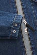 Close-up front view of Stone Island Blue denim jacket showing denim made of pure cotton with typical material texture, slim fit, two-way zipper, turn-down collar, patch chest pocket, and compass badge on upper arm.