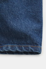 Stone Island Blue denim jacket close-up from front, showing denim made of pure cotton with typical texture, slim fit, two-way zipper, turn-down collar, patch chest pocket, and compass badge on upper arm.