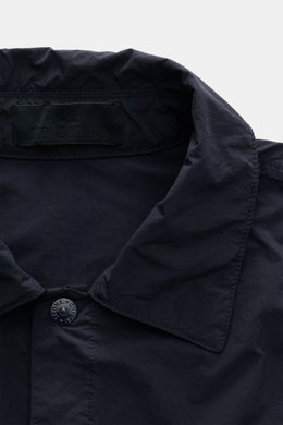 Nahaufnahme des Umlegekragens und Stone Island Label innen, Frontansicht des Stone Island Overshirt 'Ghost Piece' navy aus Microfaser, Slim Fit, garment dyed, mit tonalem Kompass-Badge, Druckknopfleiste und Brusttaschen.