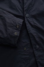 Nahaufnahme des Stone Island Overshirt 'Ghost Piece' navy aus hochwertiger Microfaser mit Druckknopfleiste, Ärmel und tonalem Badge.
