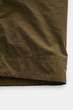 Stone Island Overshirt 'Ghost Piece' dark olive in Nahaufnahme, gewaschene Microfaser, Slim Fit, tonales Kompass-Badge, ungefüttert, von vorne fotografiert.