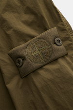 Nahaufnahme des tonalen Kompass-Badges und Druckknopfs am Ärmel des Stone Island Overshirt 'Ghost Piece' dark olive aus leicht griffiger Microfaser.