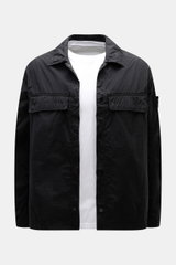 Stone Island Overshirt 'Ghost Piece' schwarz frontal fotografiert, Slim Fit, Microfaser, tonale Brusttaschen, Kompass-Badge, Druckknopfleiste.