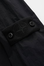 Stone Island Overshirt 'Ghost Piece' schwarz, Detailaufnahme von Ärmel mit tonalem Kompass-Badge, Microfaser, Slim Fit, Druckknopf.