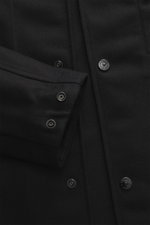 Nahaufnahme des Stone Island Overshirts 'Ghost Piece' schwarz, Mix aus Schurwolle und Microfaser, weicher Griff, Slim Fit, Fünf-Knopf-Leiste, Umlegekragen, tonales Badge am Oberarm, Ärmelabschlüsse mit Knopf, eine Innentasche, Detailansicht von Vorderseit
