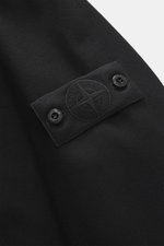 Nahaufnahme des tonalen Badges am Oberarm des Stone Island Overshirt 'Ghost Piece' schwarz aus Schurwolle-Microfaser-Mix mit weichem Griff.