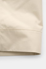 Stone Island Overshirt 'Ghost Piece' beige aus Baumwollcanvas, Slim Fit, Umlegekragen, Brusttaschen, tonales Badge, Zwei-Wege-Reißverschluss, Detailaufnahme des Ärmels.