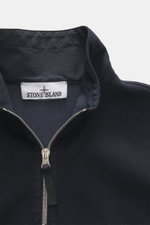 Close-up front view of Stone Island Overshirt navy showing high-closing two-way zipper, firm felted fabric of virgin wool and microfiber, elastic cuffs, patch chest pocket with flap, typical compass badge, slim fit, garment dyed, and unlined design.