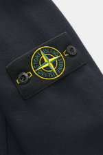 Close-up front view of Stone Island Overshirt navy showing typical compass badge on patch chest pocket with flap, made of virgin wool and microfiber, firm felted quality, garment dyed, slim fit, high-closing two-way zipper, elastic cuffs, and unlined.