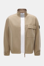 Front view of Stone Island Overshirt beige, slim fit with mix of virgin wool and microfiber, garment dyed, firm felted quality, high-closing two-way zipper, patch chest pocket with flap, typical compass badge on sleeve, elastic cuffs, and unlined.