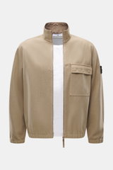 Front view of Stone Island Overshirt beige, slim fit with mix of virgin wool and microfiber, garment dyed, firm felted quality, high-closing two-way zipper, patch chest pocket with flap, typical compass badge on sleeve, elastic cuffs, and unlined.