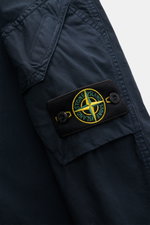 Close-up side view of Stone Island Overshirt 'Canvas' navy sleeve showing patch pocket with flap, compass badge, and durable canvas fabric.