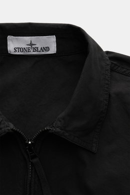 Close-up front view of Stone Island Overshirt 'Canvas' black, showing turn-down collar, durable zipper, and brand label inside collar, made from pure organic cotton canvas with robust utility design. Robust utility look with iconic character: This overshi