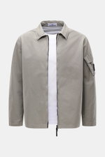 Stone Island Overshirt 'Canvas' grau, frontal fotografiert, robustes Utility-Design aus Bio-Baumwolle, Kompass-Badge am Ärmel, Regular Fit, Zwei-Wege-Reißverschluss, Umlegekragen, ungefüttert.