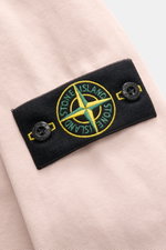 Close-up, angled view of the compass badge on the upper arm of the Stone Island Overshirt Dusky Pink, showcasing its pure cotton, slightly textured fabric.

Description:  
<p>Timeless layering essential: The STONE ISLAND overshirt complements autumn and w